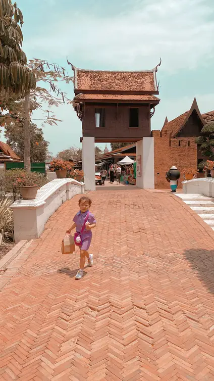 Little girl walking on old bridge at old market town in Bangkok Ancient City